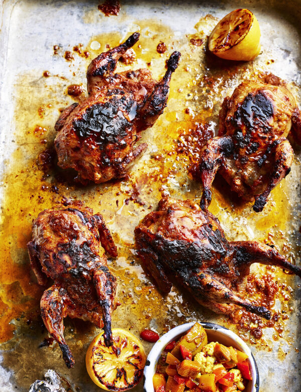 Food product photography showing four honey roasted quails, charred for flavour with a side of salsa.