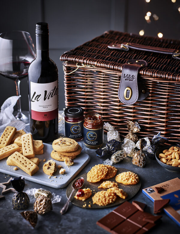 Food photography for advertising created for M&S magazine showing a Christmas hamper filled with wine, biscuits and chocolate.